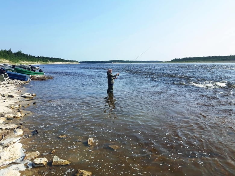 A woman fishing in a river.