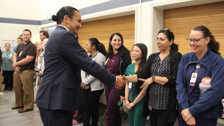 A man shakes the hand of a woman