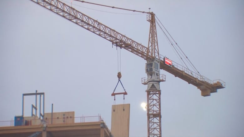 A yellow crane near a construction site. 