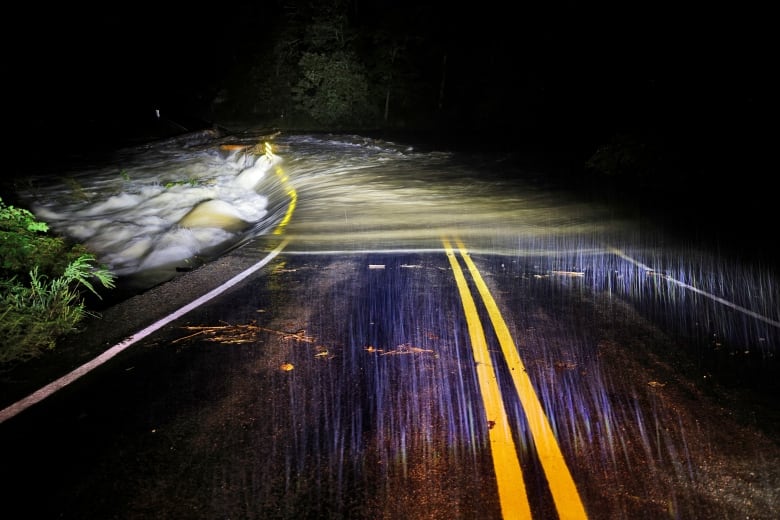 A roadway is shown deluged with water in a nighttime scene.