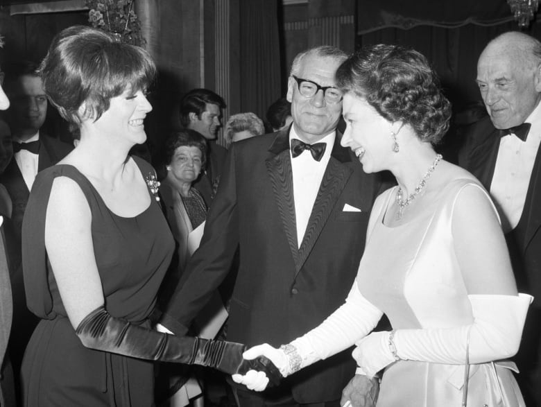 Black and white photo of an actress meeting a young Queen Elizabth