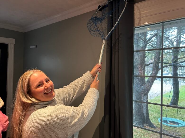 A smiling woman holding a net.