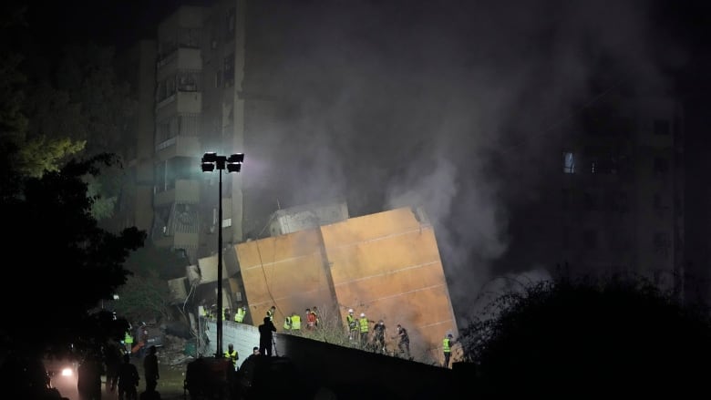 Rescuers arrive at the site of an Israeli airstrike in Beirut's southern suburbs on Friday, Sept. 27, 2024.