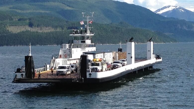 A small car ferry crosses a lake.