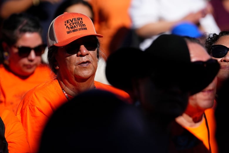 An attendee wears a hat with the motto 