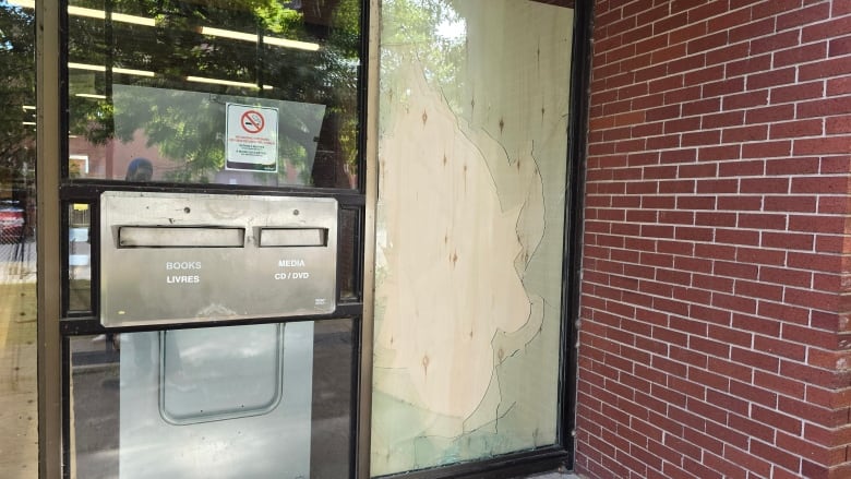 A boarded up smashed window.