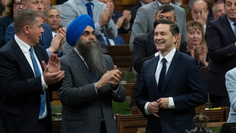 Conservative Leader Pierre Poilievre smiles as he rises to vote on an opposition motion, in Ottawa, Tuesday, Oct. 1, 2024.