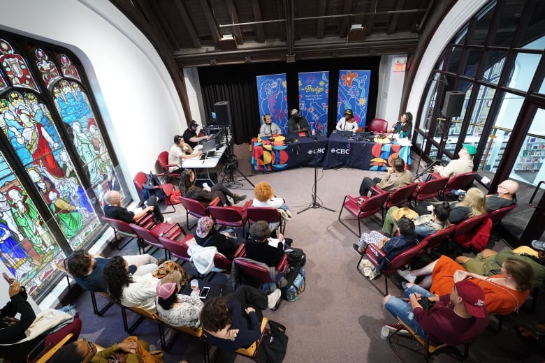 An audience looking at members of a panel. 