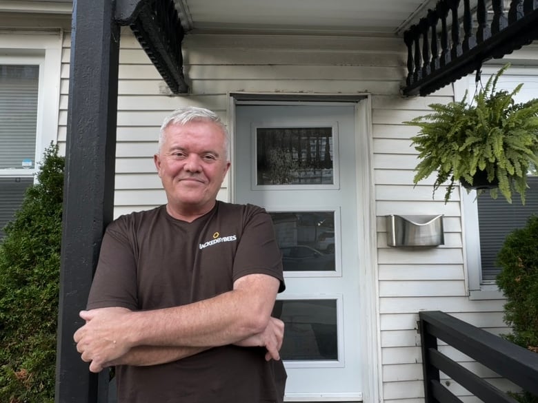 A man standing in front of a house.