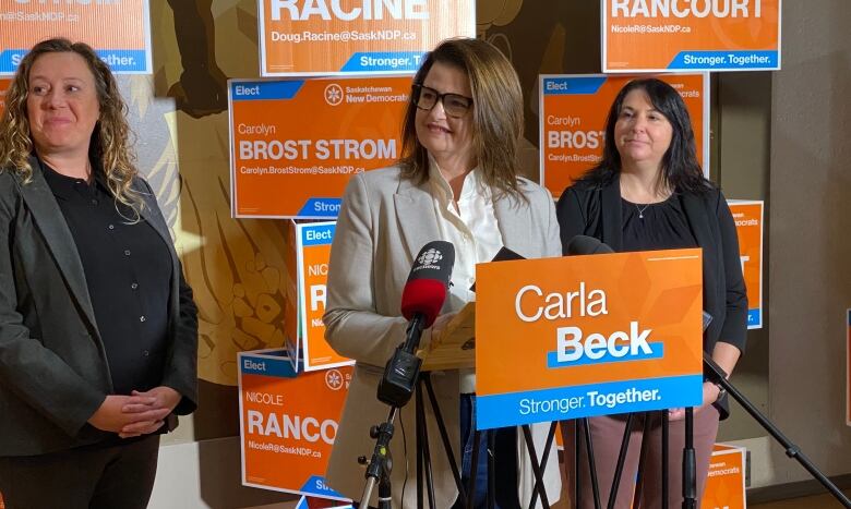 NDP Leader Carla Beck (centre) spoke in Prince Albert beside candidates Carolyn Brost Strom (left) and Nicole Rancourt (right).