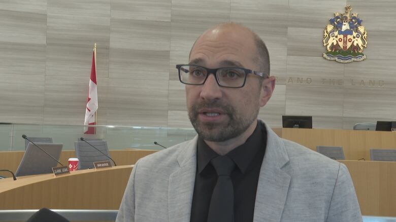 A man wearing glasses and a suit in a municipal building.