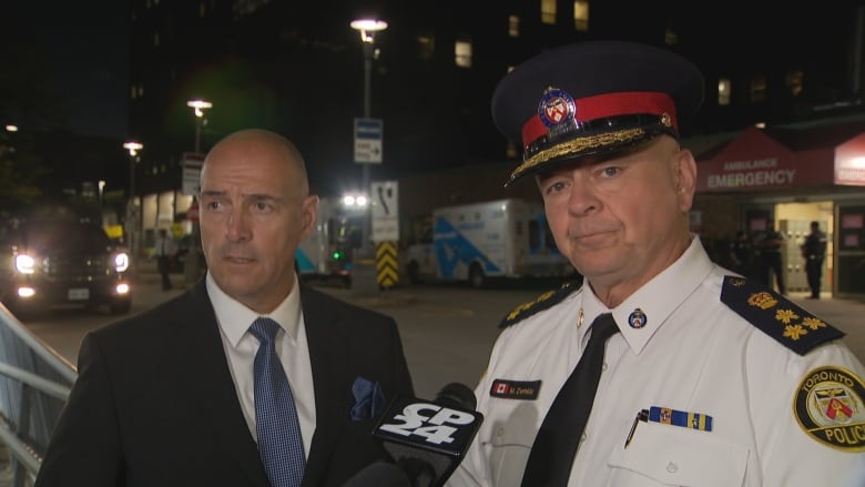 Toronto Police Chief Myron Demkiw, right, speaks to reporters outside of Sunnybrook Health Sciences Centre on Wednesday night.