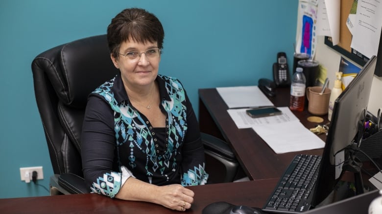 A woman sits at a desk.