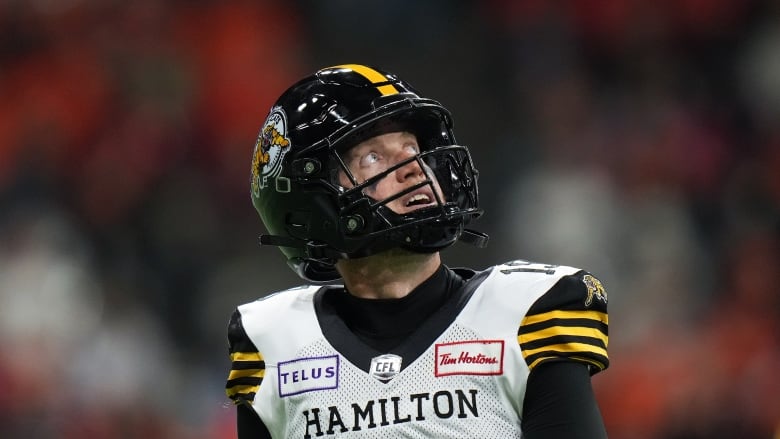 Hamilton Tiger-Cats quarterback Bo Levi Mitchell looks at the replay as he walks off the field during the first half of a CFL football game against the B.C. Lions, in Vancouver, on Friday, September 27, 2024. 