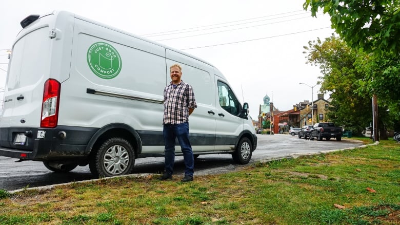 <Man stands in front of delivery van