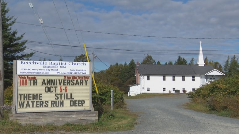 Beechville Baptist Church sign with white church in the background