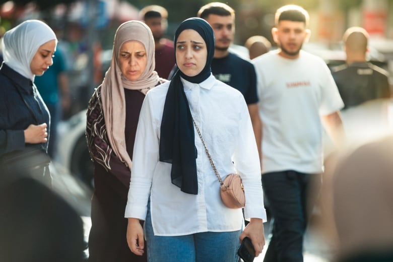 People are seen walking down a street.