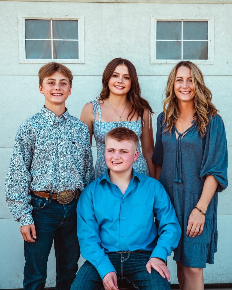 A family wearing shades of blue pose for a professional photograph.