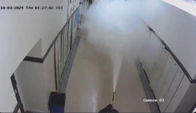 What appears to be a fire extinguisher is sprayed down a school hallway at Windsor Islamic High School.