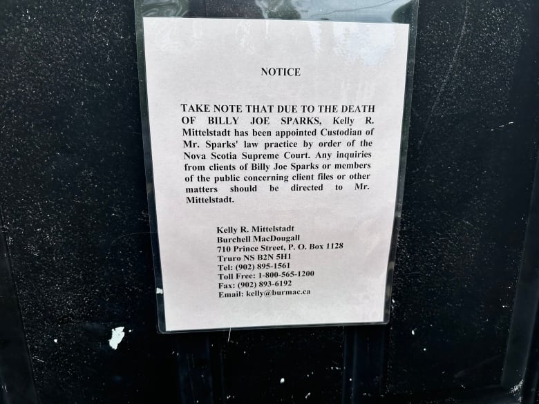 A notice taped to a black background is shown.