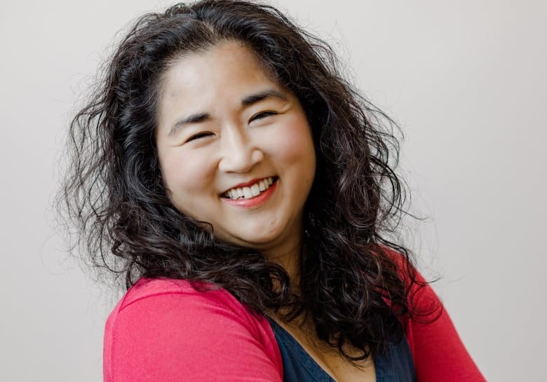 Dr. Yuka Asai crosses her arms while smiling at the camera.