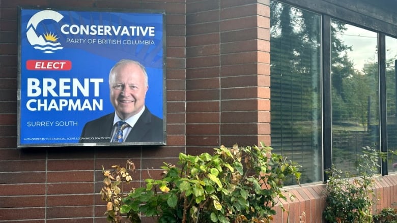 A picture of a white-haired Conservative candidate's poster on the side of a building with the Conservative logo overtop the words, Elect Brent Chapman.