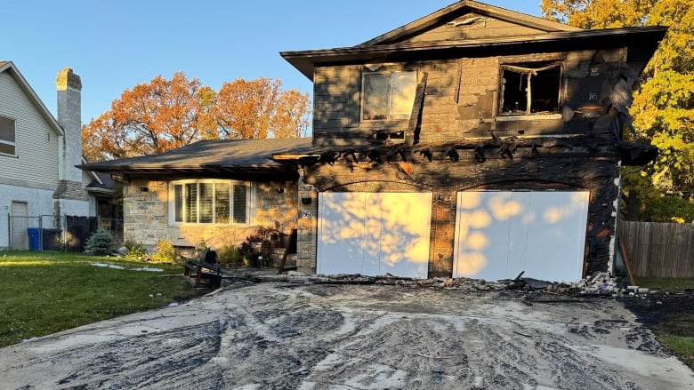 The exterior of a house, charred and covered in soot after a fire