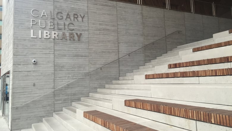 Steps leading into the main branch of the Calgary Public Library. Sign for library on wall behind.