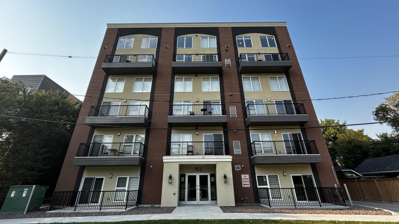 The exterior of a modern four-storey building with street-facing balconies.