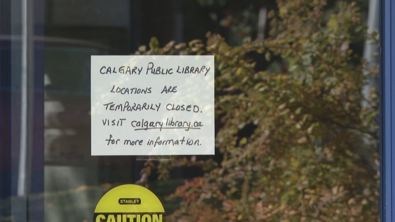 A glass door with a sign posed that reads 