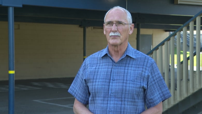 Profile shot of man in glasses wearing a checked shirt. 