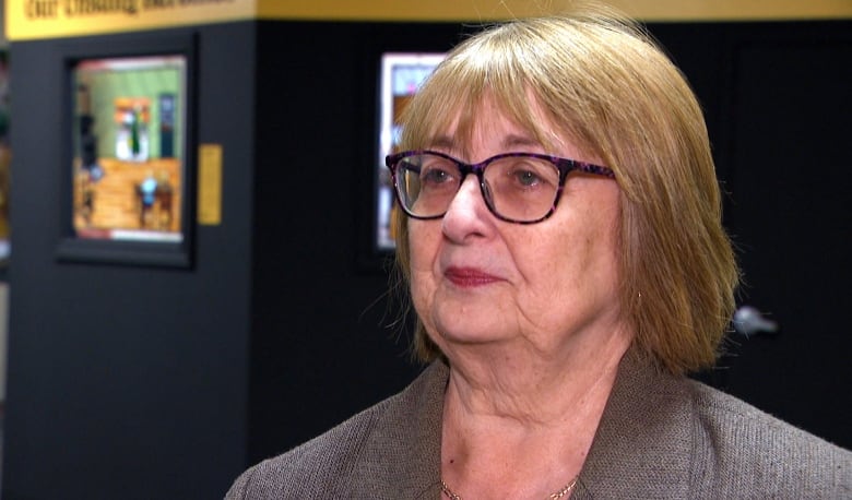 Woman with short hair and glasses.