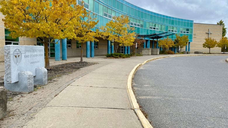 The front of a brick building. There is a cross on the building and a sign that reads 'St. Michael Catholic High School.'