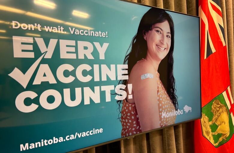 A TV screen shows an advertisement for a vaccine