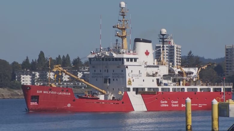 A red ship sails into the inner harbour in Victoria.