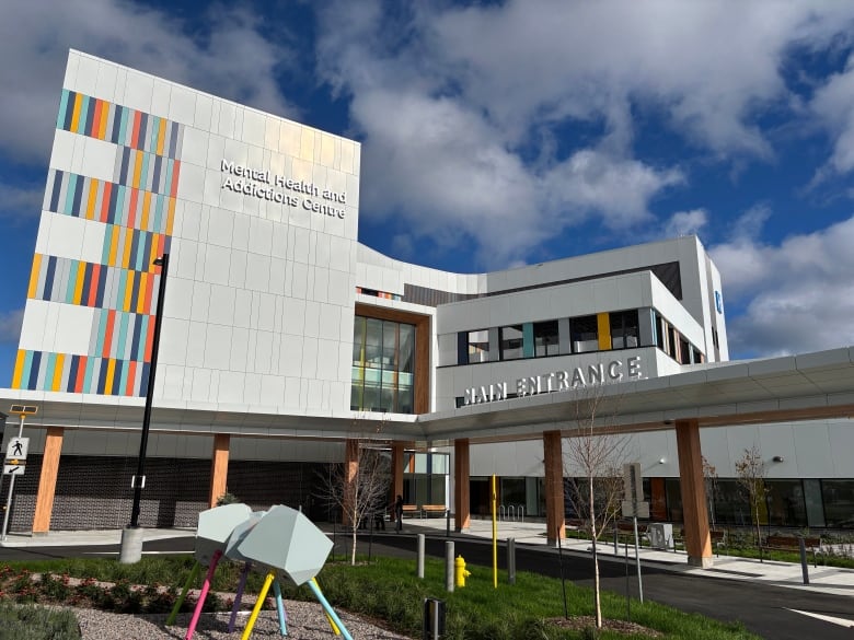 A large care centre with grey panelling and colourful windows.