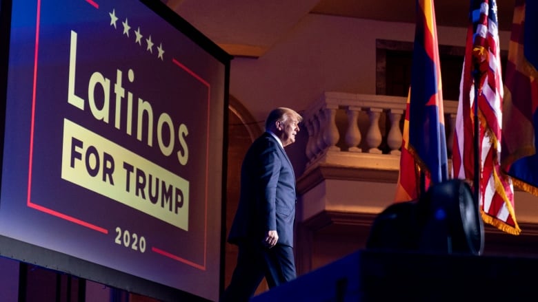 Trump in front of a Latinos for Trump sign