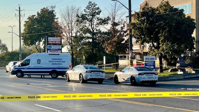 Photo of police cars and police tape at a plaza