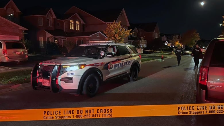 Police car in front of a house behind police tape