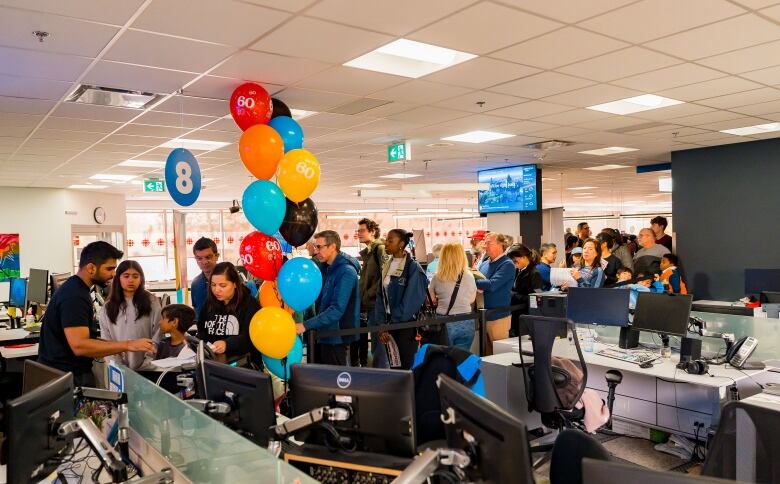 interior of an office with people in it, and colourful balloons