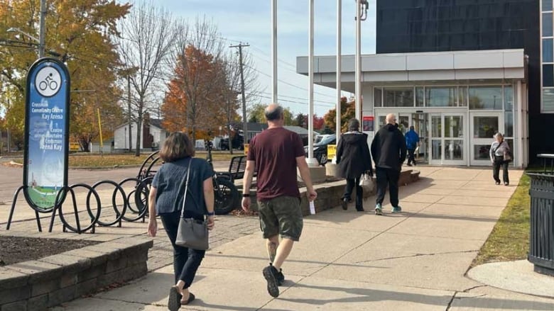 People entering and exiting the Crossman Community Centre/Kay Arena in Moncton, a polling station in the New Brunswick election.