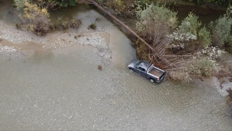 An aerial view of a truck in a river.