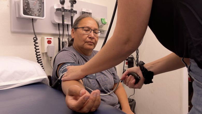 A woman gets her blood pressure checked.