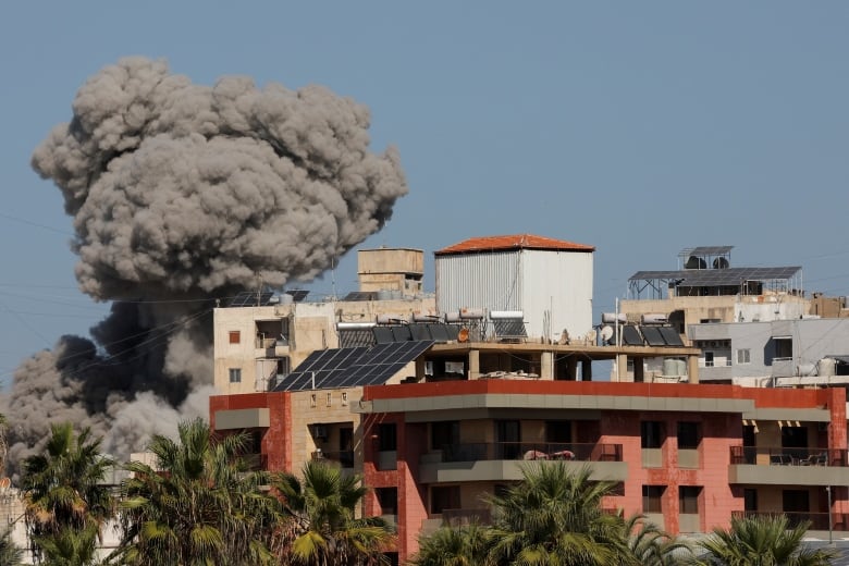 Black smoke billows from a building.