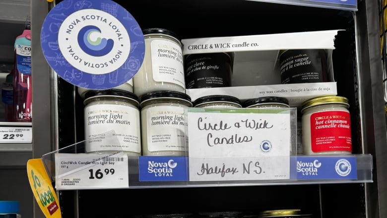 Candles are on store shelf with signs saying Nova Scotia Loyal.