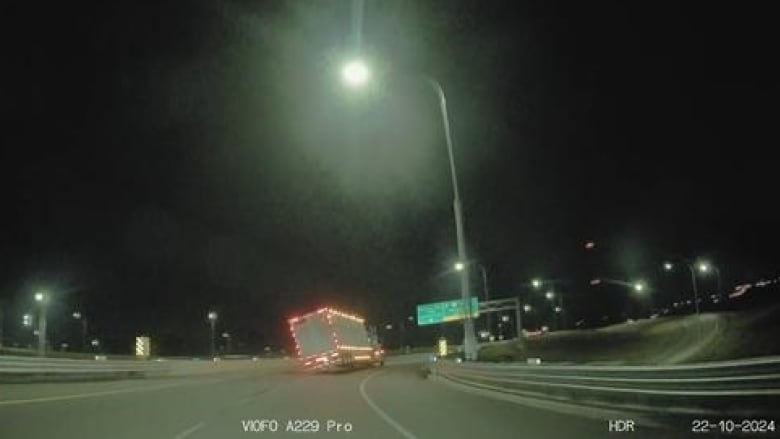 A cattle liner on a highway in the dark. 