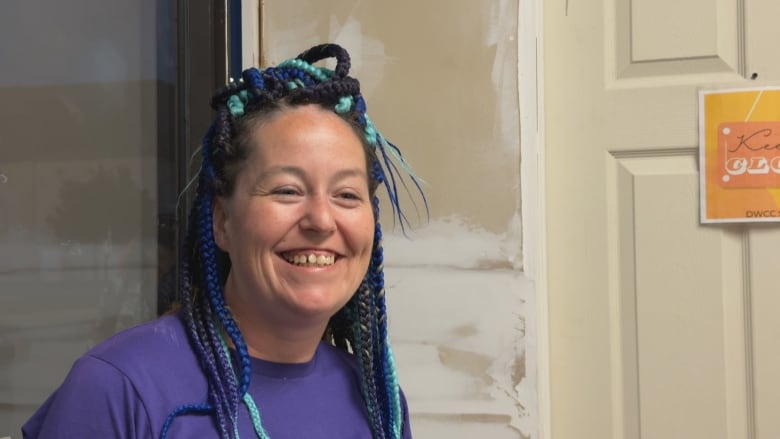 A woman in a purple shirt smiling