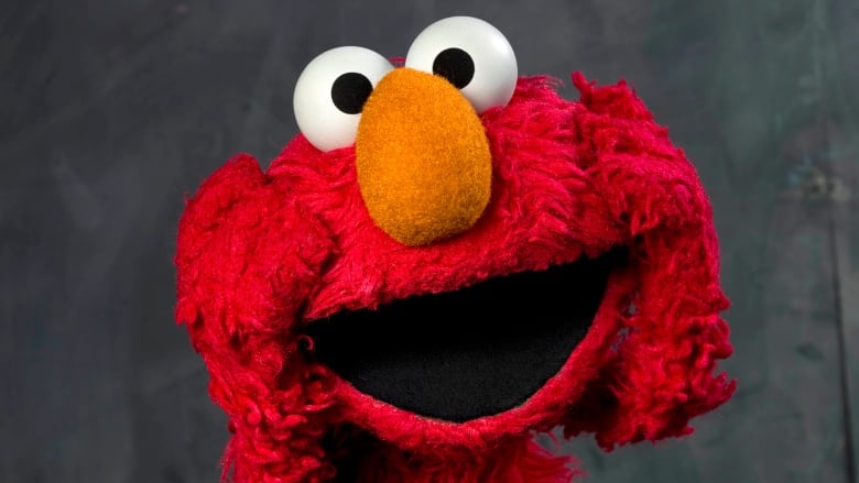 A big red muppet with floppy ears, bulging eyes and an orange nose.