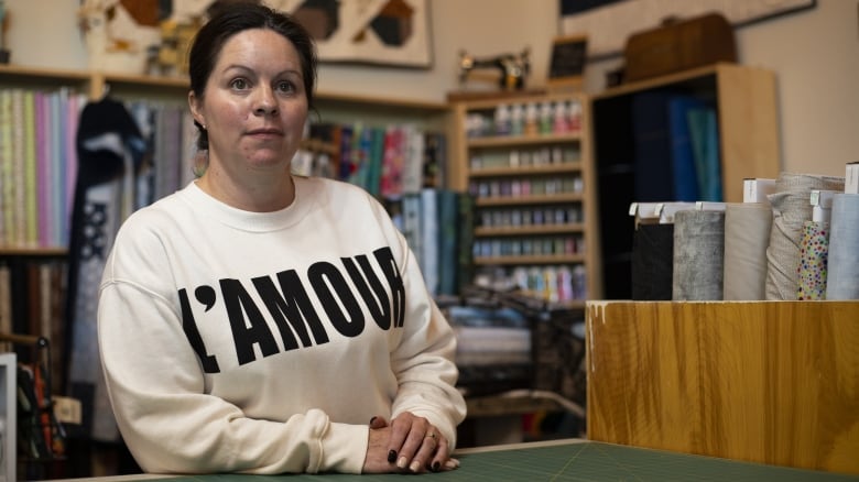 A woman stands at a desk.