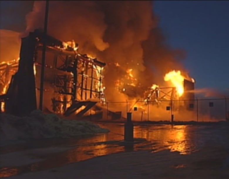 A fire rips through a large building at night time